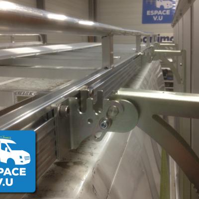 Patte de fixation entre la galerie et le pupitre latéral du fourgon d'une entreprise de menuiserie.